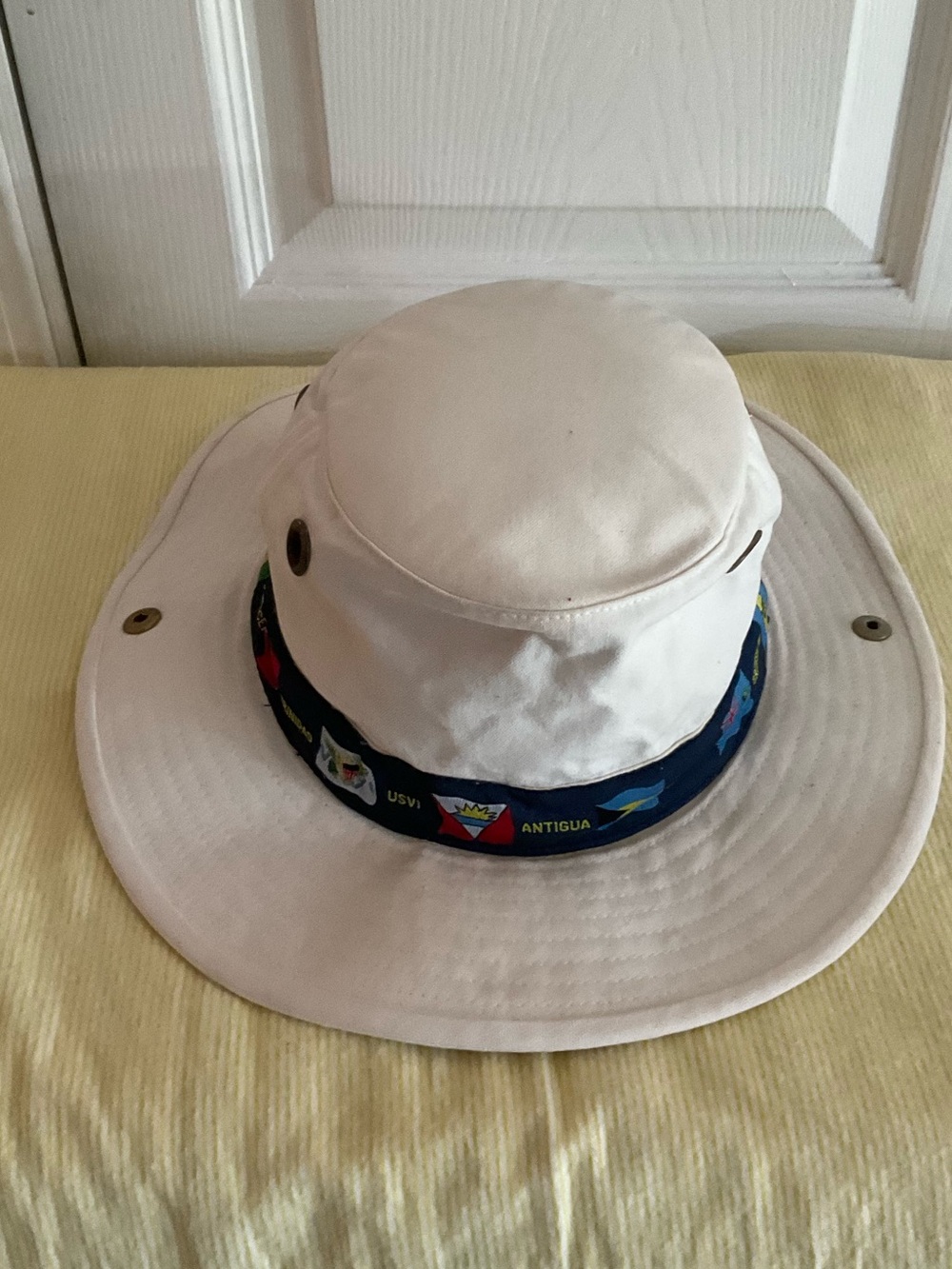 Tilley Endurables bucket, distinctive blue Caribbean flag band on white canvas.